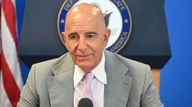 Tom Barrack takım elbise içinde basın toplantısında mikrofonun önünde duruyor, 11 Temmuz 2025